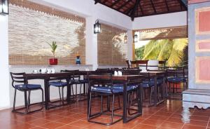 a restaurant with wooden tables and blue chairs at Blue Pillars Kandy in Kandy