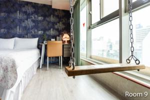 a bedroom with a swinging bed and a table at Ezstay Station in Kaohsiung