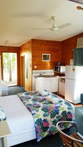 Cette chambre comprend un grand lit et une cuisine. dans l'établissement Bargara Gardens Boutique Villas, à Bargara