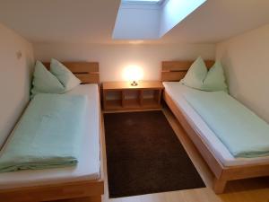 2 Betten in einem kleinen Zimmer mit einer Lampe in der Unterkunft Ferienwohnung Lenz in Bad Hofgastein