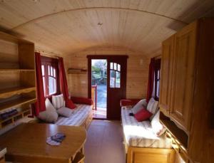 a room with two couches in a tiny house at Les Roulottes & Cottages du Moulin in Chenillé-Changé
