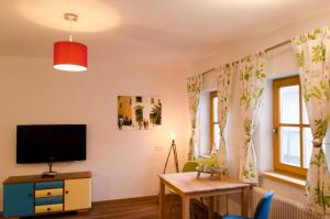 uma sala de estar com uma televisão e uma mesa em PinkDeer em Hallstatt