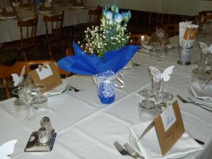 Hotel Fior di Roccia في غابي: طاولة بيضاء عليها مزهرية زرقاء من الزهور