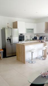 a kitchen with white cabinets and a stainless steel refrigerator at Nina Villa in Rab