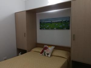 - une petite chambre avec un lit et un tableau mural dans l'établissement Palazzo Graziano, à Terrasini