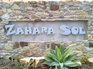 a sign on the side of a stone wall at Zahara Sol Villas y Apartamentos by QHotels in Zahara de los Atunes