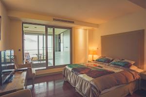 a bedroom with a large bed and a balcony at Cedarwood Villa in Tai'an