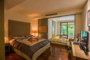 1 dormitorio con 1 cama grande y TV en Cedarwood Villa, en Taian