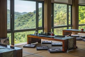 Habitación con ventanas grandes y vistas a la montaña. en Cedarwood Villa, en Taian