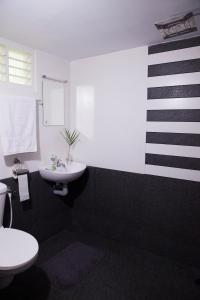 a black and white bathroom with a sink and a toilet at Mi Casa Tu Casa Homestay in Cochin
