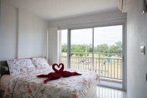 a bedroom with a bed with a heart on it at Grand Beach Condo B404 by Malai in Klaeng +37 photos
