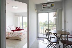 a bedroom with a bed and a table and a dining room at Grand Beach Condo B404 by Malai in Klaeng