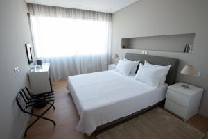 una camera con un letto bianco e una finestra di Athens Center Panoramic Flats ad Atene