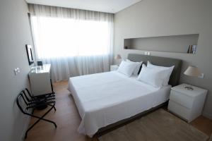 ein Schlafzimmer mit einem weißen Bett und einem Fenster in der Unterkunft Athens Center Panoramic Flats in Athen
