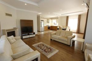 a living room with a couch and chairs and a television at Guzel Evler Family Resort in Sapanca