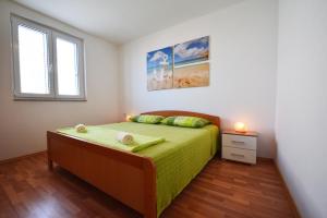 a bedroom with a bed with a green bedspread at Apartments Barbati in Kustići