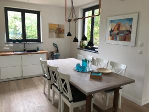 een keuken en eetkamer met een tafel en stoelen bij Rezydencja Zofia in Sianów