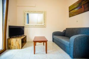 un soggiorno con divano, TV e tavolo di "Hermes" central apartment ad Argostoli