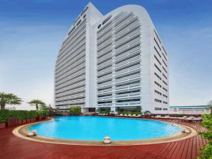 a large building with a large swimming pool in front of it at Centre Point Silom in Bangkok