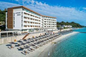 un hôtel sur la plage au bord de l'eau dans l'établissement Ammon Zeus Luxury Beach Hotel, à Kallithéa Halkidikis
