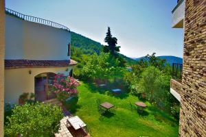 een gebouw met een tuin met tafels en bloemen bij Ephesus Boutique Hotel in Kirazli