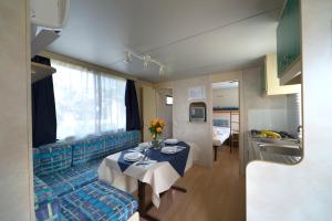 a living room with a table and a blue couch at Villaggio Diomedea in Campomarino