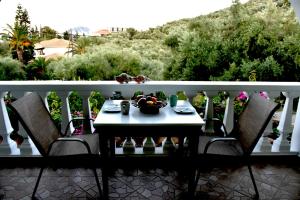 a table with a bowl of fruit on a balcony at Mersina Apartments in Keri