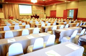 a conference room with tables and chairs and a podium at Muaklek Paradise Resort in Ban Muak Lek