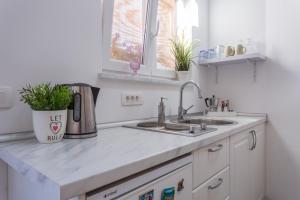 a kitchen counter with two sinks and a window at Studio Villa Ivka in Baška