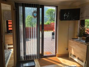 an open sliding glass door in a room with a deck at The Wee Ludging Cottage, Rashfield, by Dunoon in Dunoon