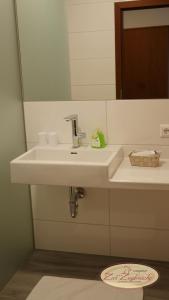 ein Badezimmer mit einem weißen Waschbecken und einem Spiegel in der Unterkunft Gasthof Schiefer Zur Zugbrücke in Bad Kreuzen