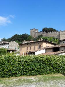 un groupe de bâtiments avec un château en arrière-plan dans l'établissement B&B AL VICOLO DI MEZZO, à Monzambano