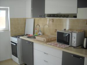a kitchen with a counter with a microwave and a sink at Casa Miki in Haţeg