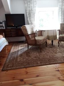 uma sala de estar com duas cadeiras e uma televisão em Zielony Raj em Siedlisko