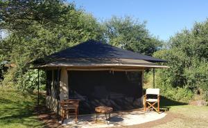 a gazebo with two chairs and a tent at Migombani Camp in Mto wa Mbu