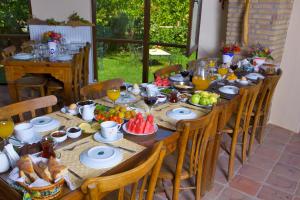a long wooden table with food and fruit on it at Ephesus Boutique Hotel in Kirazli