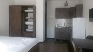 a kitchen with a bed and a sink and a refrigerator at Studio apartment with great view in Ureki