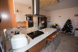 a man standing in a kitchen with a christmas tree at B&B AL VICOLO DI MEZZO in Monzambano