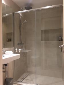 a shower with a glass door next to a sink at Apartment P 35 in Dubrovnik