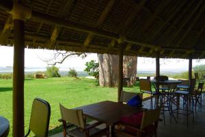 a group of tables and chairs with a view of a field at Migombani Camp in Mto wa Mbu