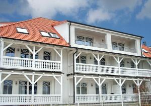 a white house with an orange roof at Haus Strandburg - hinter Düne und Meer in Binz