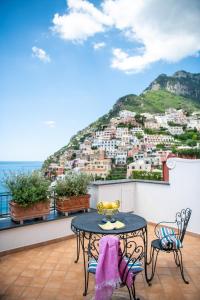 a balcony with a table and chairs and a mountain at Alcione Residence in Positano