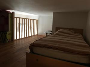 um quarto com uma cama e piso em madeira em Bastide Ecurie Massilia em Aubagne