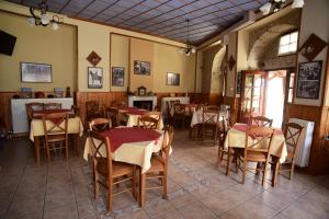 a restaurant with tables and chairs in a room at Gkoura hotel in Syrrako
