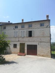 um grande edifício de tijolos com duas portas de garagem em Casa Vacanze da Peppa em Grottazzolina