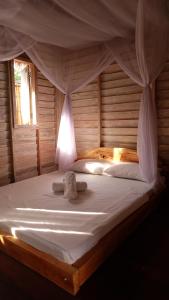 un grande letto bianco con baldacchino in una stanza di Beranda Ecolodge a Gili Air