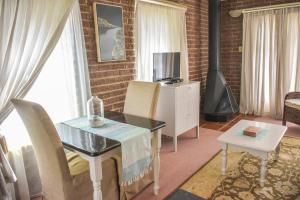 a living room with a desk and a table and a television at Clarens Retreat in Clarens