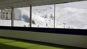 a view of a snow covered mountain from a window at TODOSIERRANEVADA ZONA BAJA - EDIFICIO ALHAMBRA - Junto a los Telecabinas in Sierra Nevada