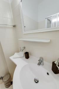 a white bathroom with a sink and a mirror at Hotel Himmelreich in Mariazell