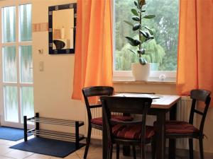a dining room table with two chairs and a window at Spacious Apartment in Boltenhagen with Garden in Tarnewitz